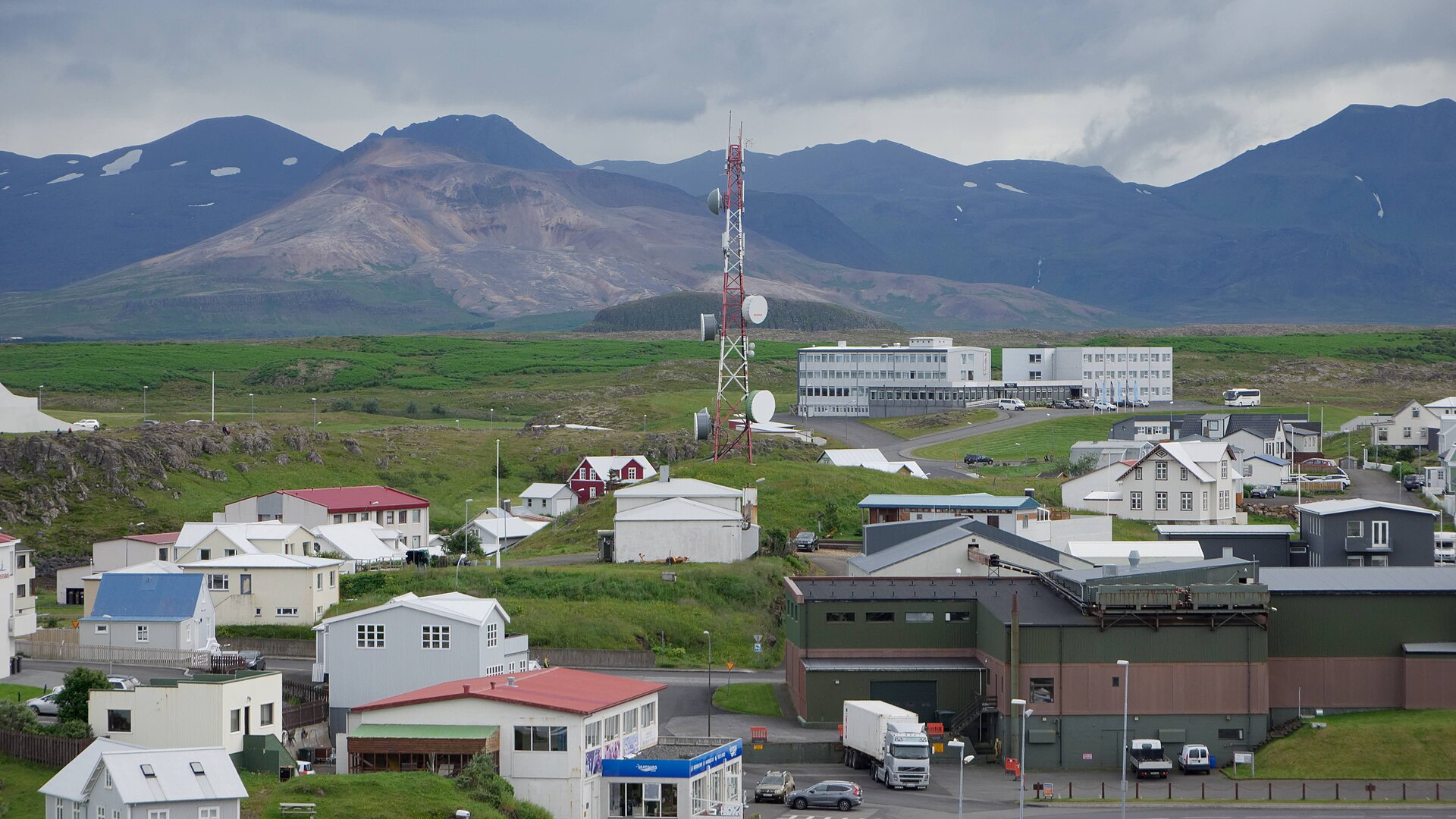 Antenne-relais de télécommunications au-dessus d'une ville, avec des montagnes en arrière-plan